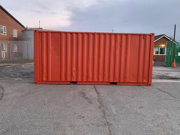 side on view of used storage shipping container painted in red